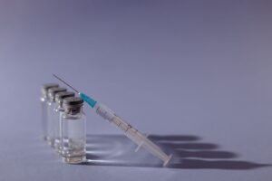 Glass medicine vials and a syringe on a table